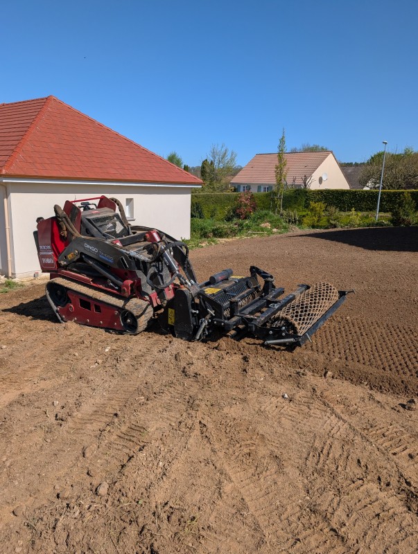 Travaux de préparation du terrain au semis d'une pelouse avec une machine performante 